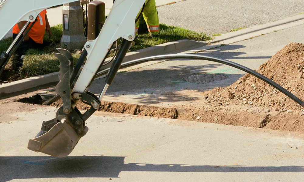 Trenching work for underground electrical lines at a business site.